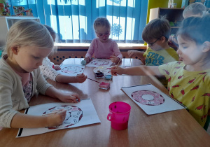 Dzieci malują farbami donuty